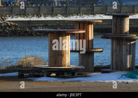 Large empty decorative wooden drums of cables which stands at the seashore Stock Photo
