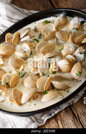 Stewed clams in creamy sauce with herbs close-up on a plate. horizontal Stock Photo