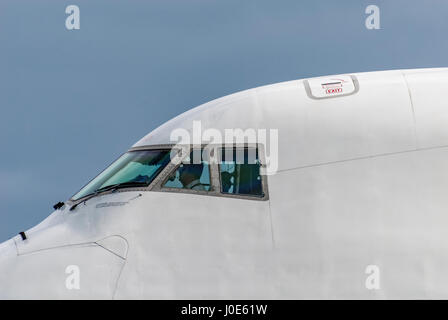 Jumbo jet Boeing 747 cockpit with pilots visible. Close uo. Stock Photo