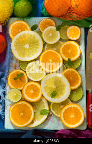 Sliced citrus fruits on blue board Stock Photo