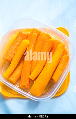 Cooked carrots in plastic container Stock Photo