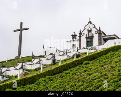 Our Lady of Peace Chapel with cross. The Nossa Senhora da Paz, a place of pilgrimage, sits on a hill with a panoramic view of Vila Franca Do Campo Stock Photo