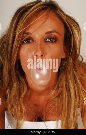 Woman eat with bubble gum on her face Stock Photo