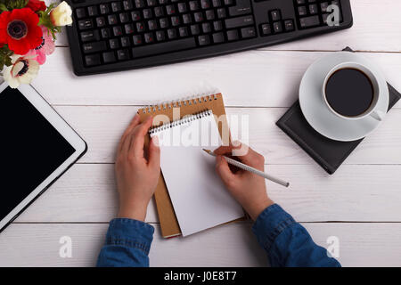 female hands writing in a notepad view from above Stock Photo