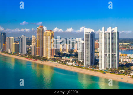 Sunny morning shot of Sunny Isles Beach in South Florida right after sunrise. White tower on the right reflecting to the Atlantic Ocean. Stock Photo