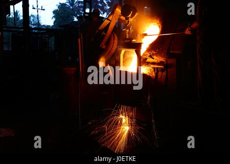 Foundry - molten metal poured from ladle for casting Stock Photo