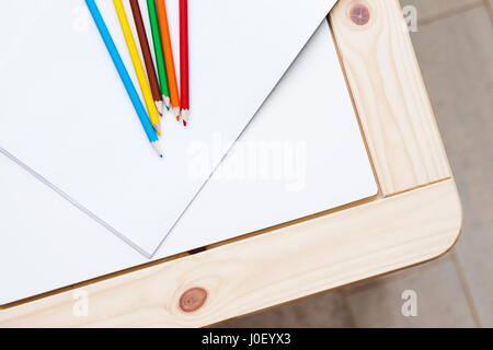 group of multicolored pencils lying on a white table Stock Photo