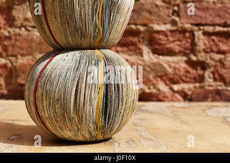 Vase from newspapers on a wooden table and wall background. Stock Photo