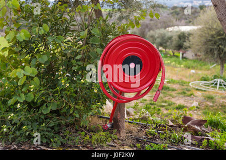 Fire safety concept - an fire hose hanging outdoors Stock Photo