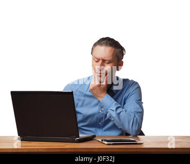 Handsome business man working on an office table with a laptop Stock Photo