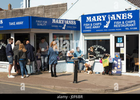 People eating fish and chips outside Mary Jane's Fish and chip shop in Cromer Norfolk UK Stock Photo