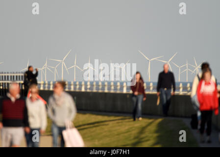 Kentish Flats Offshore Wind Farm and Red Sands Maunsell Fort in the mouth of the Thames Estuary off the Essex and Kent coasts. Walkers in evening sun Stock Photo