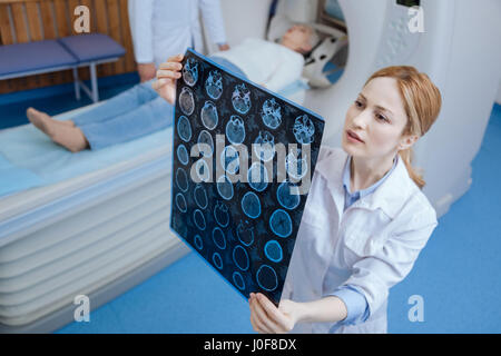 Experienced professional oncologist looking at the MRI scan results Stock Photo