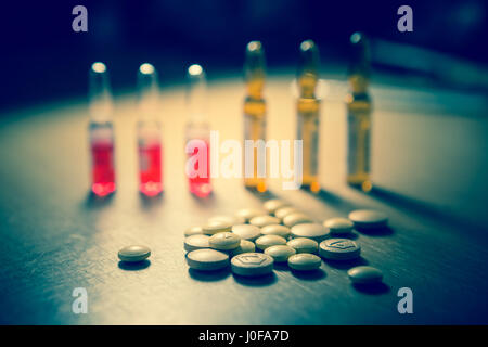 Pharmaceutical medicaments: pills and ampules isolated on wooden table. Selective focus. Toned photo Stock Photo