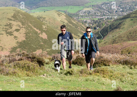Man and woman walking puppy dog on The Long Mynd Carding Mill Valley in South Shropshire Uk Stock Photo