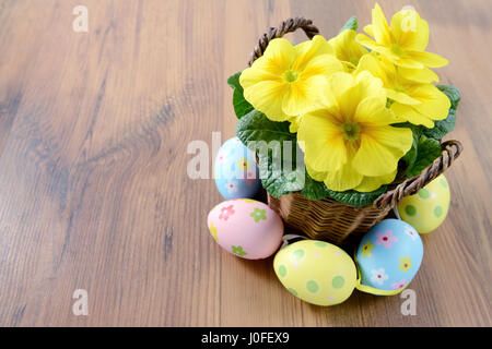 Easter decoration. yellow  primrose in flowerpots with easter eggs. wooden background Stock Photo