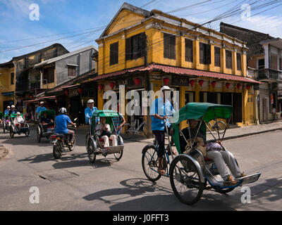 Horizontal view of cyclos in convoy in Hoi An, Vietnam. Stock Photo