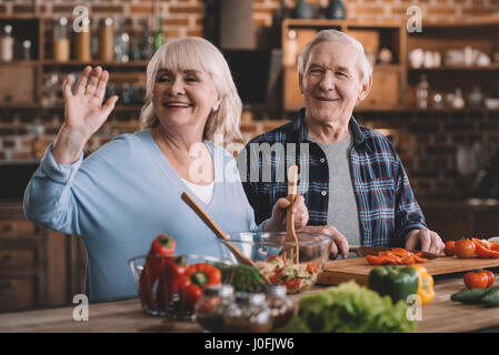portrait of smiling senior couple making salad together Stock Photo