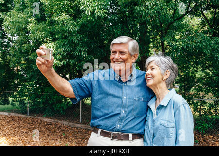Senior Couple Taking Selfie in Park Stock Photo
