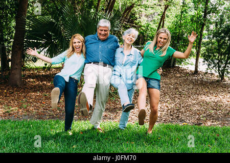 Senior Couple and Two Adult Daughters in Park Having Fun Stock Photo