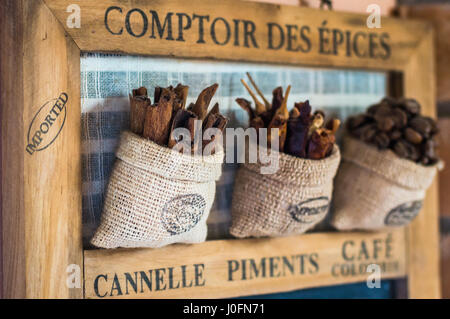 Close up view cinnamon sticks in little sack bag hanging on the wooden board Stock Photo