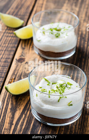 Raw  lime cheesecake in a glass on wooden rustic table Stock Photo