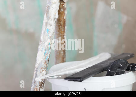 house improvement by worker puts finishing layer of stucco on the wall using a plastering trowel Stock Photo