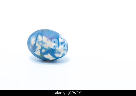 Easter egg hand painted in home - abstract colors dark blue, white, purple - isolated in white background Stock Photo