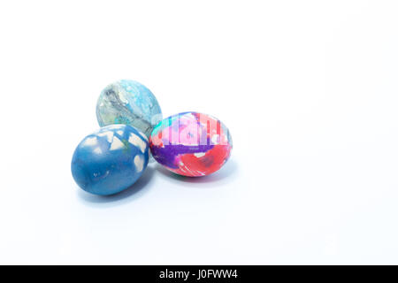 Three easter eggs hand painted in home - abstract colors dark blue, pink, rosa, white, purple - isolated in white background Stock Photo