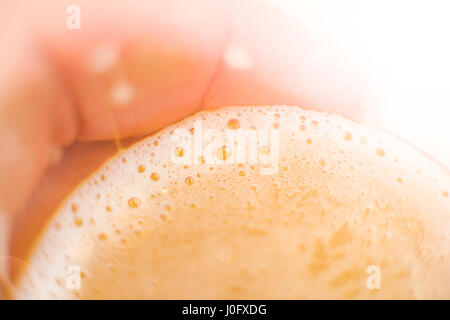 Beer with foam in hand Stock Photo