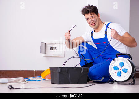 Funny Man doing electrical repairs at home Stock Photo