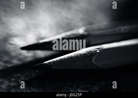 Two different pencils on a bluish surface. Stock Photo