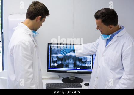 Dentist examining x-ray report on computer in clinic Stock Photo