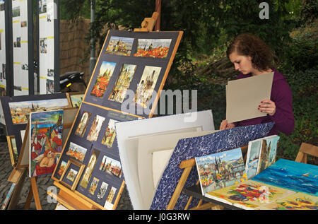 a young woman selling art on the street  in Prague, Czech Republic Stock Photo