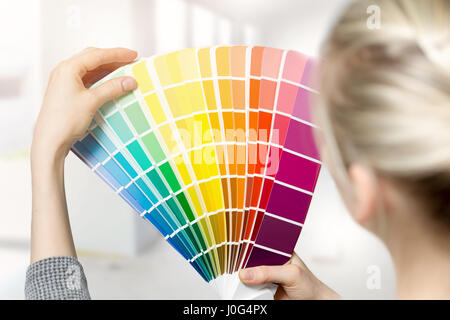 woman selecting home interior paint color from swatch catalog Stock Photo