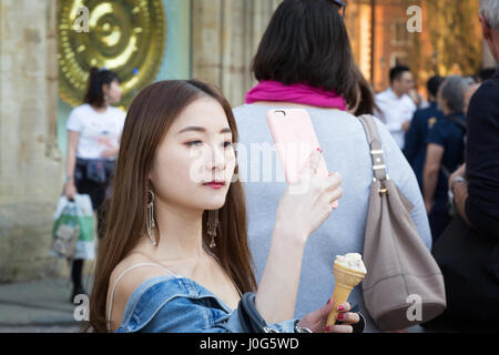 Tourist UK; Asian woman taking a selfie on her mobile phone, Cambridge UK Stock Photo