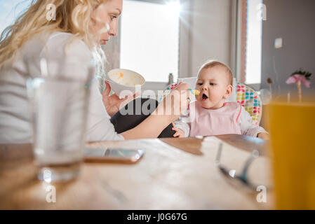 Mother feeding baby at home Stock Photo