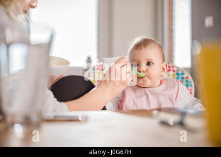 Mother feeding baby at home Stock Photo
