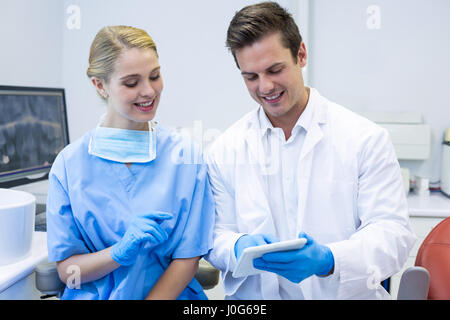 Happy dentist and nurse using digital tablet in clinic Stock Photo