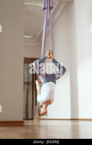 Yoga. Aerial yoga Yoga air. Yoga on the horn. Yoga exercises. Yoga positions. Yoga. Antigravity yoga.A woman is practicing yoga on a hose, aerial yoga Stock Photo