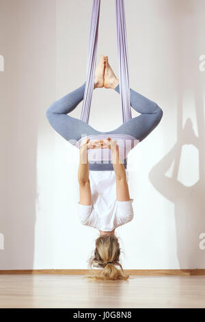 Yoga. Aerial yoga Yoga air. Yoga on the horn. Yoga exercises. Yoga positions. Yoga. Antigravity yoga.A woman is practicing yoga on a hose, aerial yoga Stock Photo