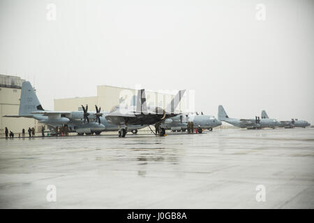 A U.S. Marine Corps F-35B Lightning II aircraft with Marine Fighter Attack Squadron (VMFA) 121 refuels using a KC-130J Hercules with Marine Aerial Refueler Transport Squadron (VMGR) 152 during aviation delivered ground refueling training at Marine Corps Air Station Iwakuni, Japan, April 11, 2017. The ADGR marked the first evolution of this form of refueling for VMFA-121’s F-35B Lightning II aircraft, and it increases the squadron’s ability to refuel by C-130 aircraft in austere locations when other resources may not be available.  (U.S. Marine Corps photo by Lance Cpl. Joseph Abrego) Stock Photo