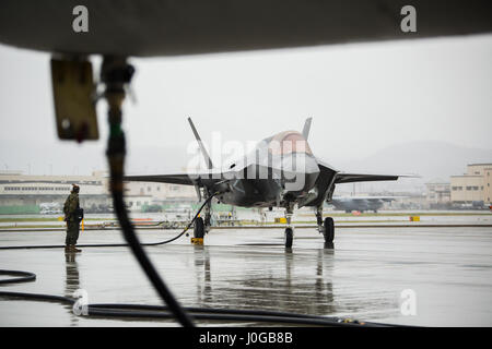 A U.S. Marine Corps F-35B Lightning II aircraft with Marine Fighter Attack Squadron (VMFA) 121 refuels using a KC-130J Hercules with Marine Aerial Refueler Transport Squadron (VMGR) 152 during aviation delivered ground refueling training at Marine Corps Air Station Iwakuni, Japan, April 11, 2017. The ADGR marked the first evolution of this form of refueling for VMFA-121’s F-35B Lightning II aircraft, and it increases the squadron’s ability to refuel by C-130 aircraft in austere locations when other resources may not be available.  (U.S. Marine Corps photo by Lance Cpl. Joseph Abrego) Stock Photo