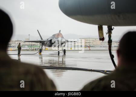 A U.S. Marine Corps F-35B Lightning II aircraft with Marine Fighter Attack Squadron (VMFA) 121 refuels using a KC-130J Hercules with Marine Aerial Refueler Transport Squadron (VMGR) 152 during aviation delivered ground refueling training at Marine Corps Air Station Iwakuni, Japan, April 11, 2017. The ADGR marked the first evolution of this form of refueling for VMFA-121’s F-35B Lightning II aircraft, and it increases the squadron’s ability to refuel by C-130 aircraft in austere locations when other resources may not be available.  (U.S. Marine Corps photo by Lance Cpl. Joseph Abrego) Stock Photo