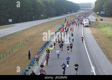 Runners of the All American Marathon move past a section of the competition that is dedicated to fallen service members Mar. 26, 2017, in Fayetteville, N.C. The memorial was put up by volunteers with the organization, wear blue: run to remember, who supported the event by lining a portion of the race with photos of fallen service members and holding flags in honor of the nation’s fallen heroes past and present. (U.S. Army photo by Pfc. Hubert D. Delany III/22nd Mobile Public Affairs Detachment) Stock Photo