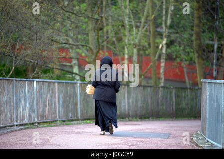 young muslim woman wearing hijab scarf walking alone in the city Stock Photo