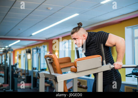 Focused man doing dips in the gym Stock Photo