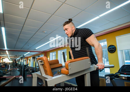 Focused man doing dips in the gym Stock Photo