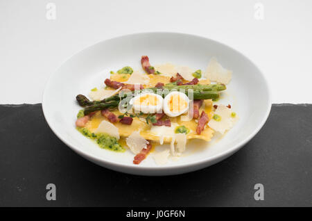 quail eggs and asparagus pasta on a white plate Stock Photo