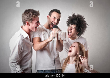 3 men and woman singing Stock Photo